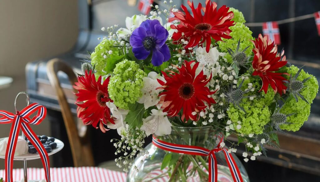 17. mai blomsterbukett med røde, hvite og blå blomster pyntet med nasjonalfarger – perfekt til feiring av nasjonaldagen i Norge.