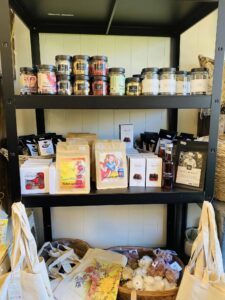 Hylle med gaveartikler, kaffe og produkter hos Stokkaveien Blomster.