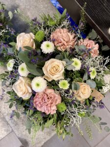 Bukett med roser, nellik og grønne blader – håndlaget av Stokkaveien Blomster.